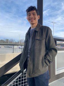 A portrait of Jorge outside in a park